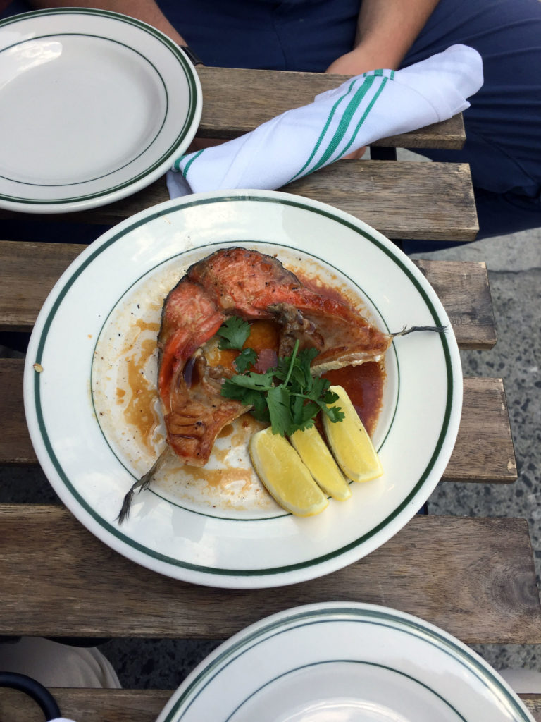 Brendan samples a fish collar from Greenpoint Fish & Lobster Co., seen here broiled in tamari, fish sauce, and lemon juice.